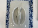 a small white and blue plate with a fish on it