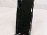 a close up of a phone on a stand on a white surface