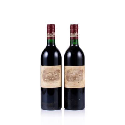 two bottles of red wine sitting next to each other on a white surface