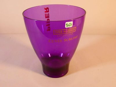 un vase en verre violet orné d'une étiquette rouge