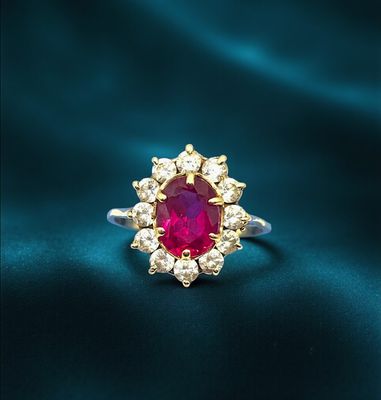 a close up of a ring with a ruby stone surrounded by white diamonds