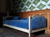 un lit recouvert d'un drap bleu dans une chambre