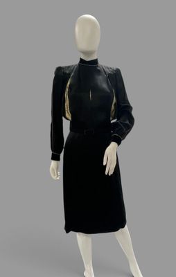an image of a mannequin wearing a black dress with gold trim