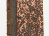 an old book sitting on top of a table next to a white background