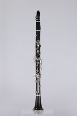 a black and silver clarinet sitting on top of a clear stand