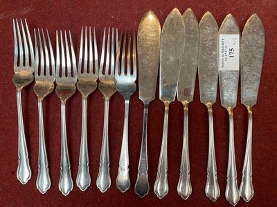 six forks and six knives on a red table