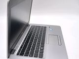 a silver laptop with a black keyboard on a white surface