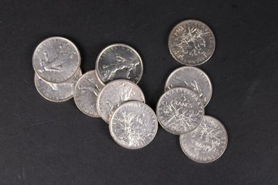 plusieurs pièces d'argent posées sur une surface noire