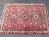 un tapis rouge sur un sol gris, sur fond bleu