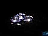 a pair of blue sapphires sitting on top of a black surface