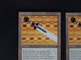 two cards with a sword on them on a table