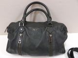 a black leather handbag sitting on top of a table next to a pair of shoes