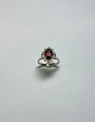 Bague en or gris 18K (750/oo) ornée d'un grenat ovale dans u…