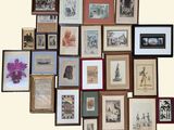 many framed pictures on the wall of this room