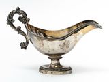 an antique silver plated gravy dish on a stand