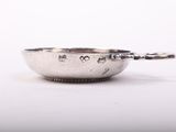 a close up of a silver bowl with a spoon in it