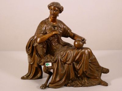 statue en bronze représentant une femme assise sur une chaise avec un chien