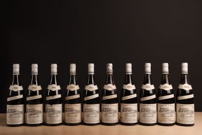 six bouteilles de vin sont alignées sur une table en bois