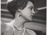 une vieille photo en noir et blanc d'une femme portant des perles et un collier