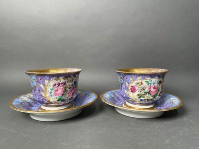 a pair of cups and saucers with floral designs on them