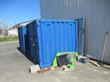 a blue container sitting in front of a blue building