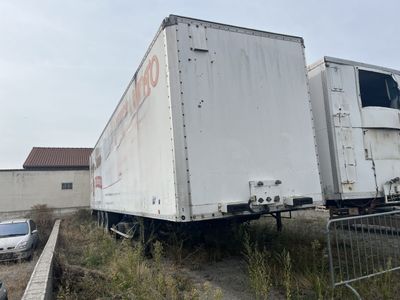 a truck that is parked in a lot next to a fence