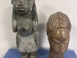 two statues of a woman and a man on a blue surface