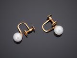 a pair of pearl and gold earrings on a black background