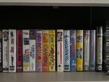 a lot of dvds on a shelf next to a cd player