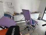 a room with a chair, a table, and a suitcase in it