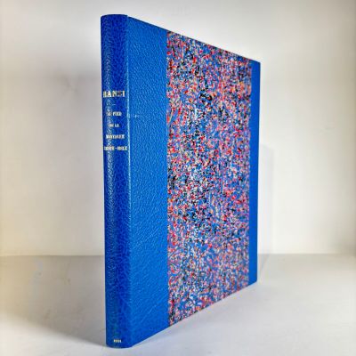a blue book sitting on top of a white table next to a white wall
