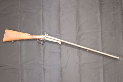 an old gun with a wooden handle on a black background