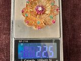 une petite balance surmontée d'une fleur en or