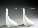 two white vases with a glass top sitting on top of a table