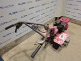 an image of a pink lawn mower parked in a garage