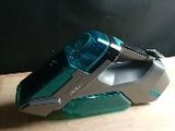 un aspirateur vert et argent posé sur une table en bois