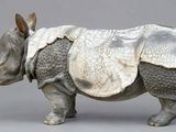 a sculpture of a rhino standing on a gray surface