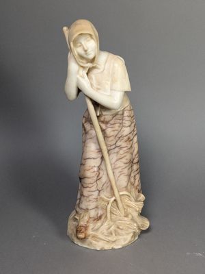 statue d'une femme tenant une serpillière à la main et portant un chapeau sur la tête