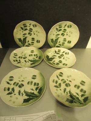 six assiettes vertes et blanches ornées de motifs, posées sur une table