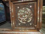 a wooden cabinet that has a carved design on it