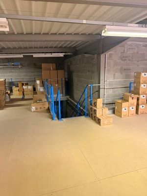 Les cartons sont empilés sur des palettes dans un grand entrepôt aux murs en béton
