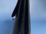 the inside of a black purse on a blue background