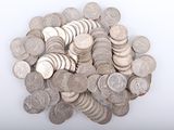 une pile de pièces d'argent posée sur une surface blanche