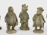 four figurines of animals that are standing in a row