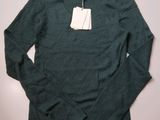 une photo d'un pull vert avec une étiquette dessus