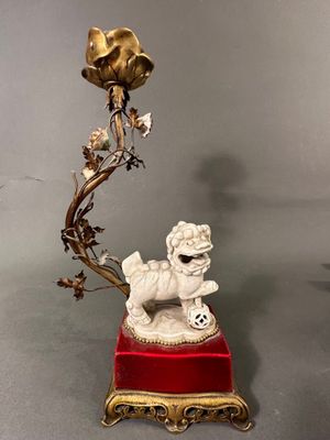 une image représentant une statue de chien sur laquelle est posée une fleur