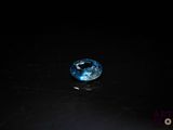 a close up of a blue diamond on a black surface