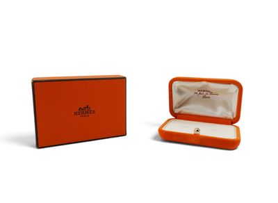 an orange box with a ring inside of it on a white surface