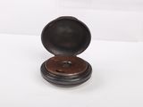an old wooden box with a metal lid on a white surface
