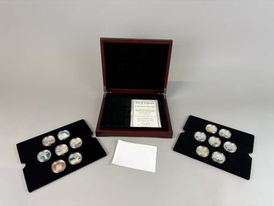 four silver coins in a wooden box with a card and envelope